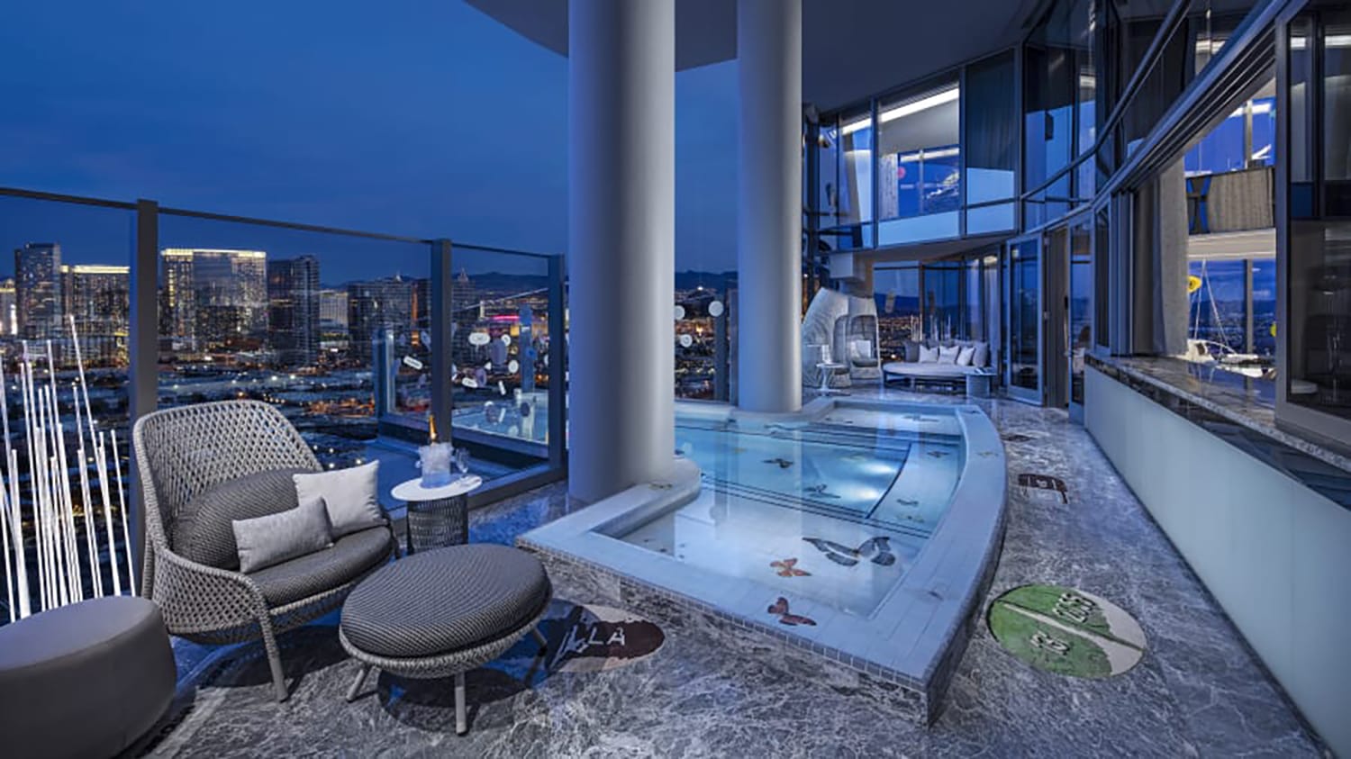 Luxurious high-rise balcony with a private pool, stylish seating, and a stunning cityscape view at night.