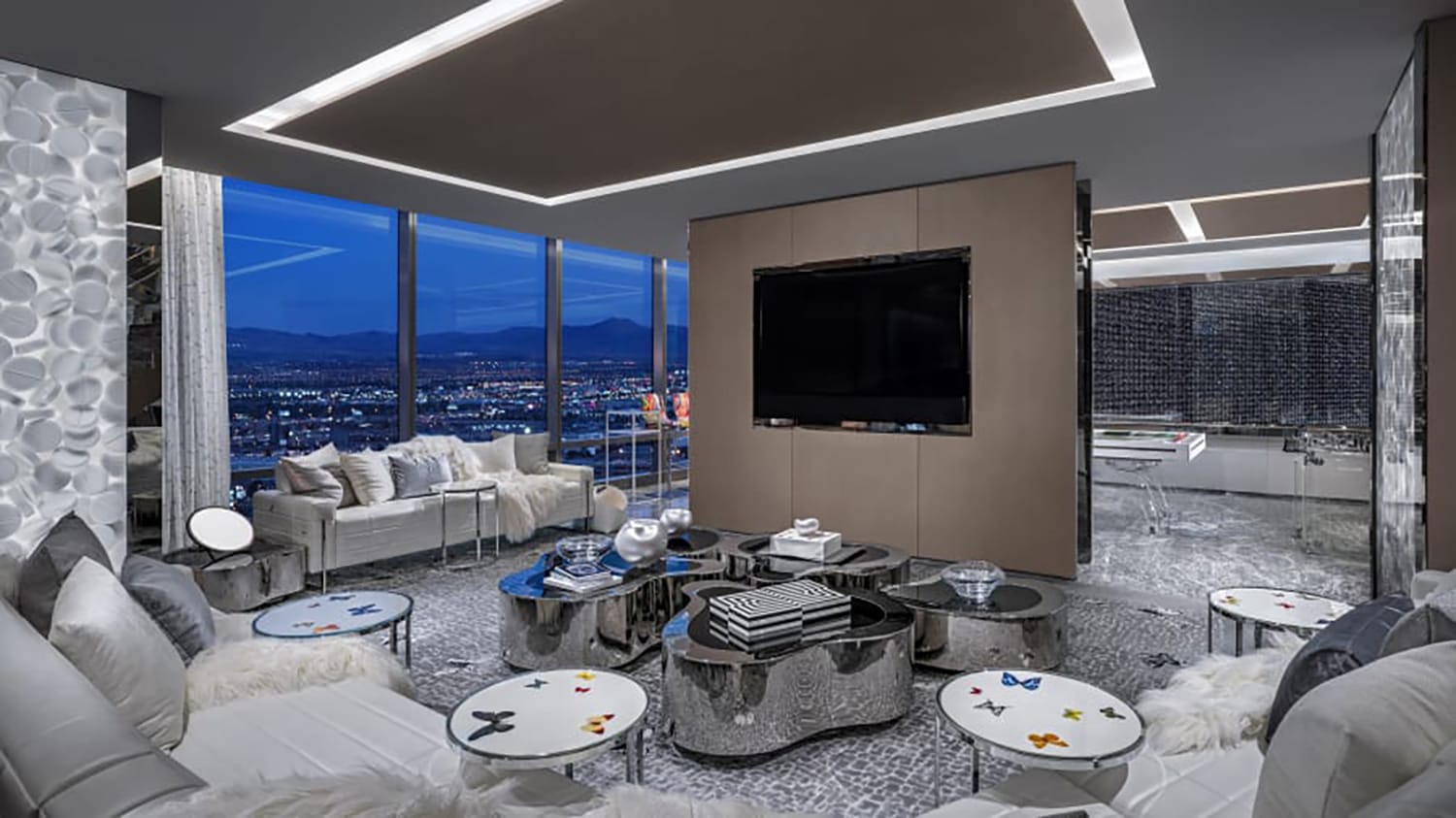 Luxurious modern living room with floor-to-ceiling windows, city view, plush seating, and sleek decor.