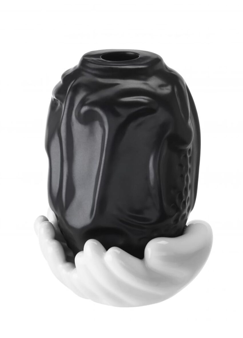 Black vase held by sculpted white hands on a white background
