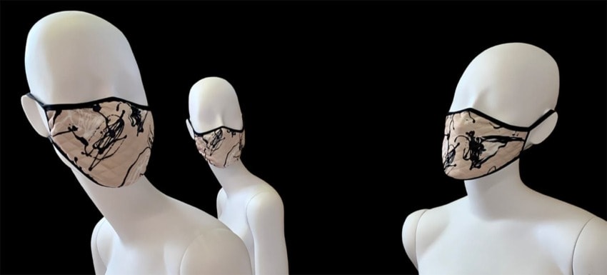 Three mannequins wearing artistic face masks with abstract patterns on a black background.