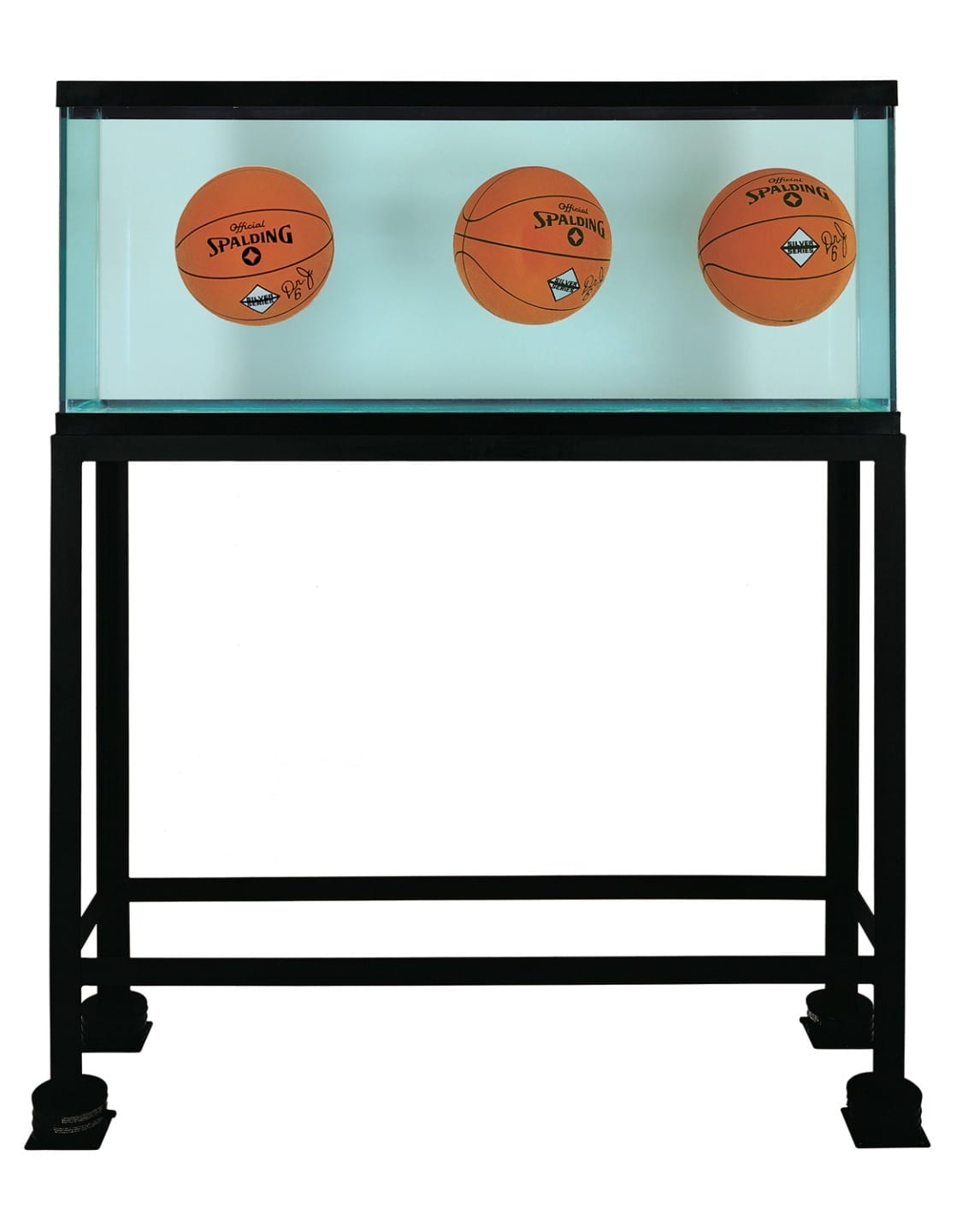 Three basketballs submerged in a clear display case filled with water, mounted on a black metal stand.