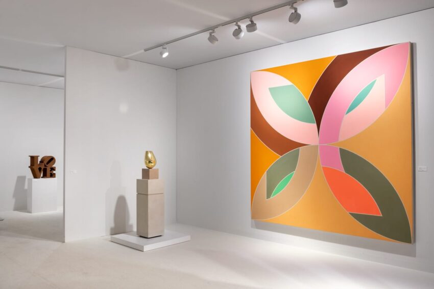 Modern art gallery with large abstract painting, sculpture on pedestal, and "LOVE" sculpture in background.