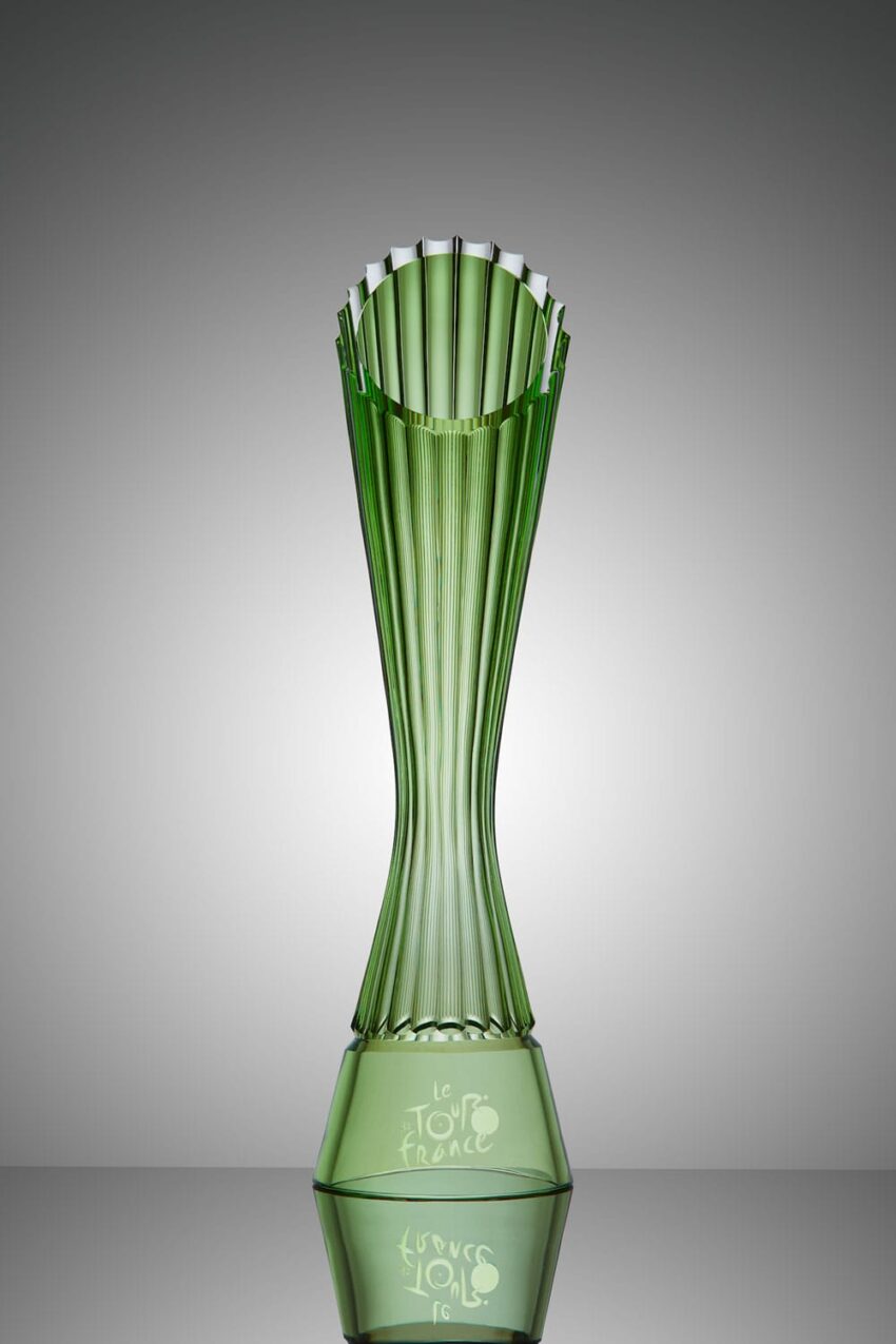Green glass trophy with "Le Tour de France" engraved, featuring a tall, elegant, fluted design set against a gray background.