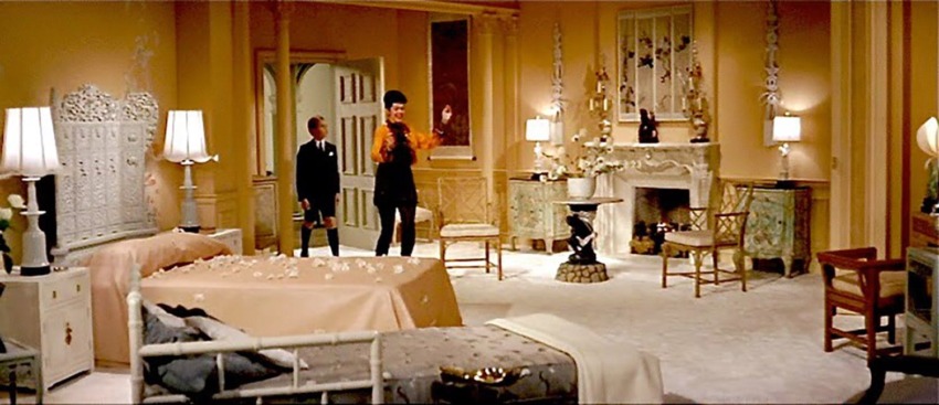 Luxurious vintage room with elegant furnishings, two people conversing, ornate fireplace, and soft lighting ambiance.