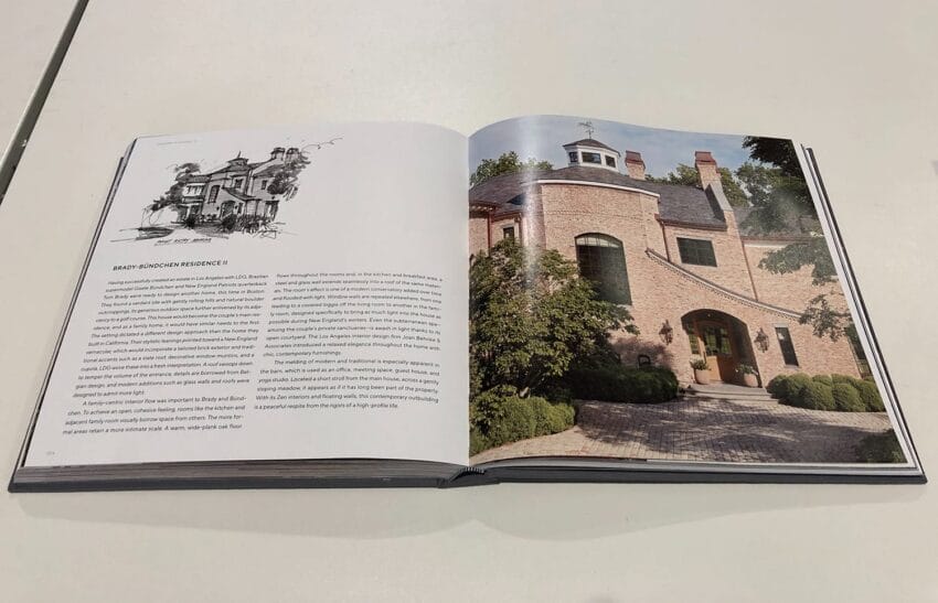 Open book on a table showing a black and white house sketch on the left page and a house photo on the right page.