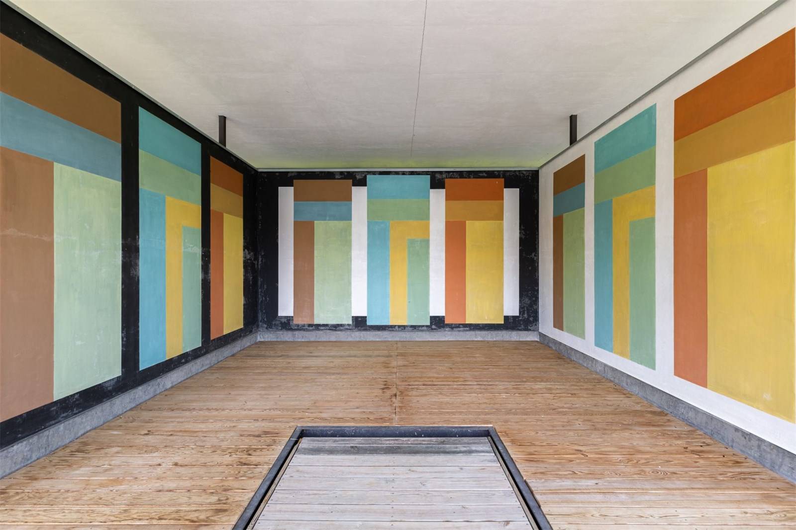 colorful abstract geometric mural on walls of a wooden floored room