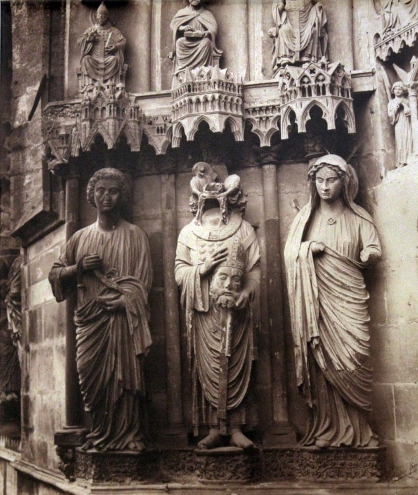 Gothic sculptures of saints on a cathedral facade, featuring detailed stone carvings and religious iconography.