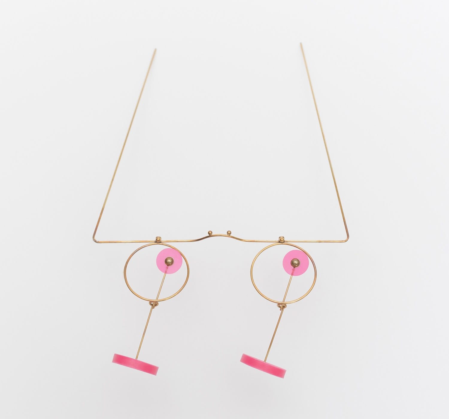 Modern minimalist eyeglasses with pink accents and gold wireframe design against a white background.