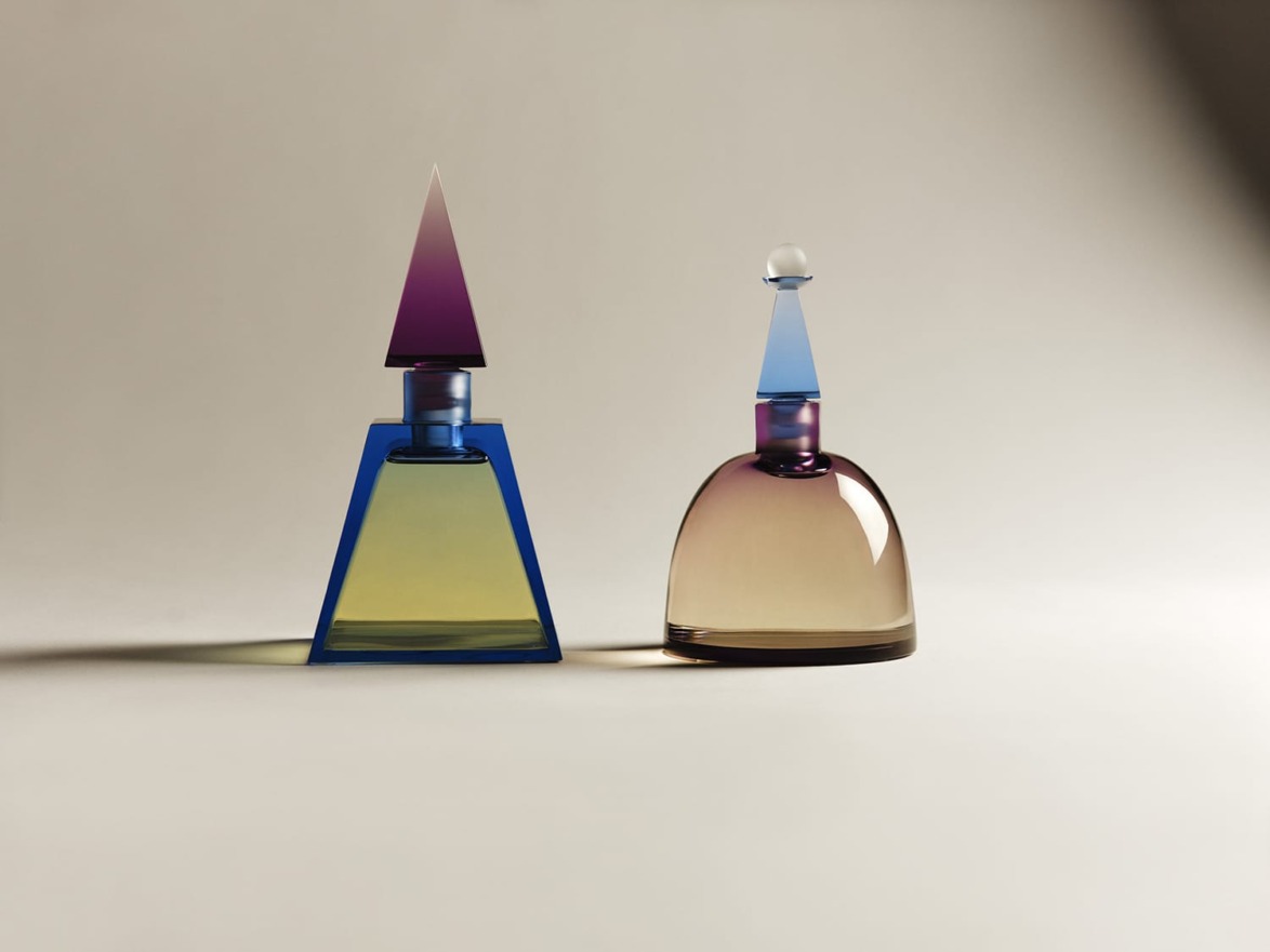 Two geometric glass bottles with colorful gradient designs on a neutral background.