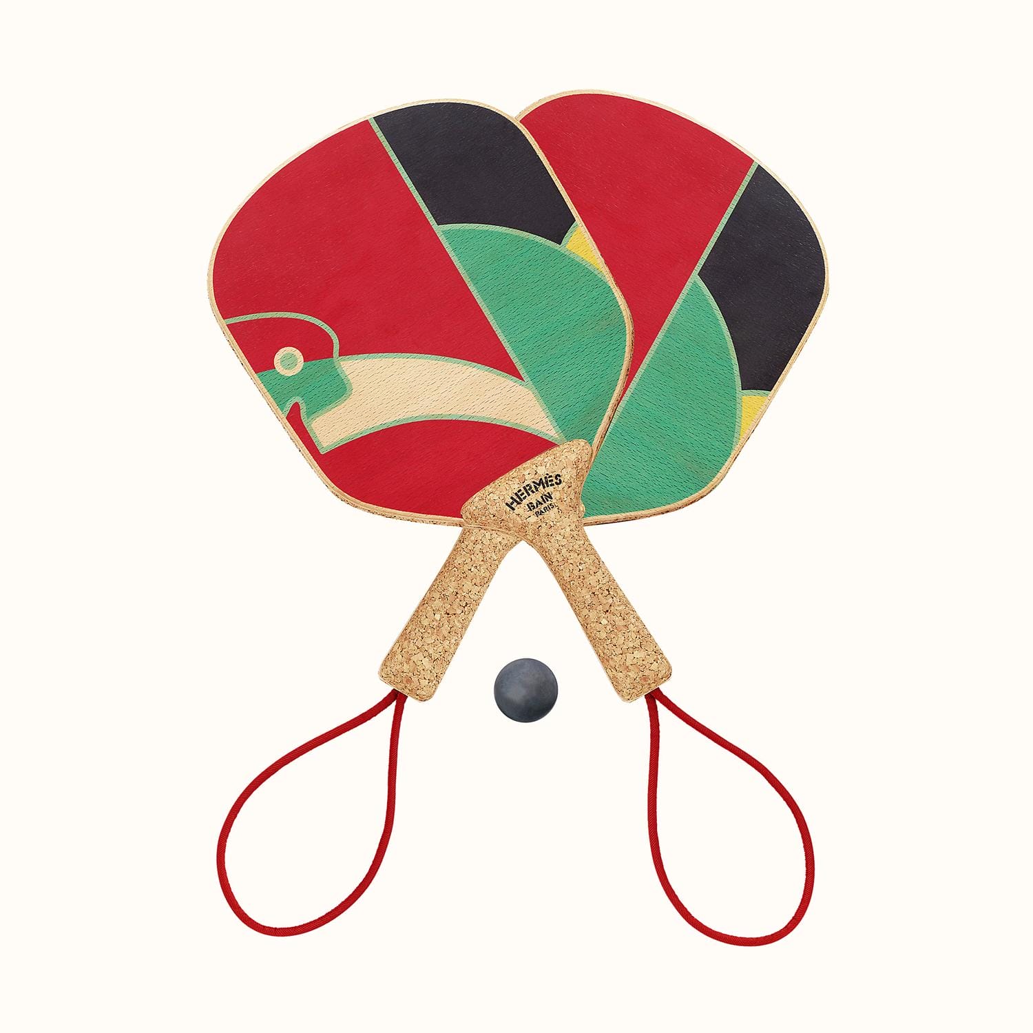 Two colorful paddle rackets with cork handles and wrist straps, positioned on either side of a small black ball.