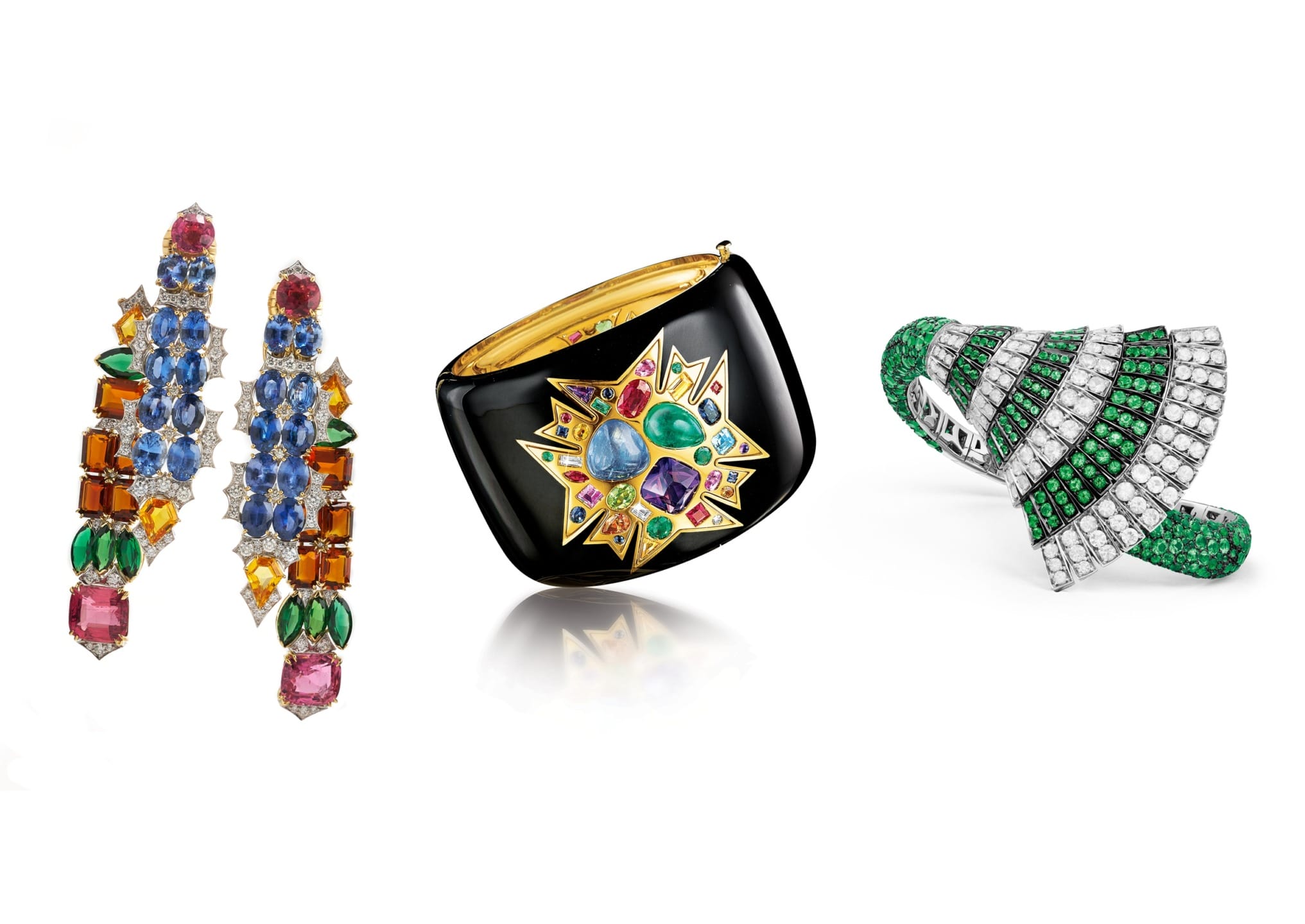 Colorful gemstone earrings, a black bangle with a star design, and a green and silver spiral ring displayed on a white background.