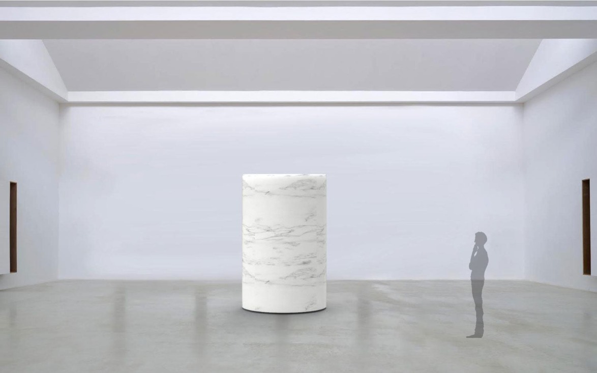A person contemplating a large cylindrical marble sculpture in a spacious white gallery with high ceilings.
