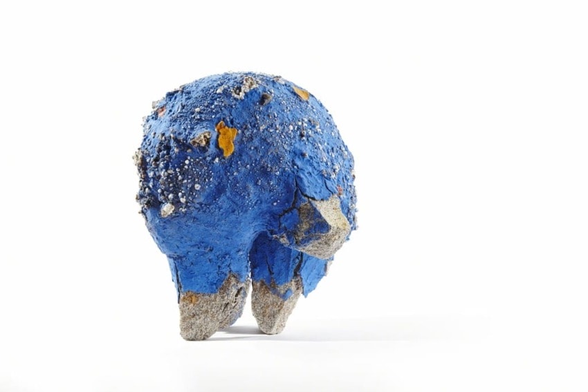 Blue and gray textured abstract sculpture with a rounded shape standing on a white background.