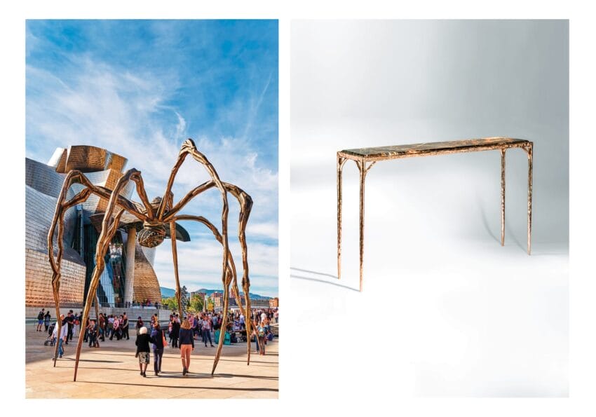 Large spider sculpture outdoors next to a museum and a sleek metal table with long legs in a white indoor setting.