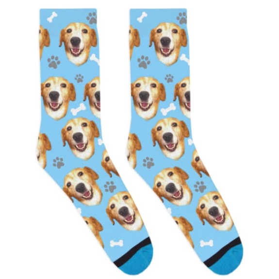 Blue socks with repeated images of a happy dog's face, white bones, and gray paw prints.
