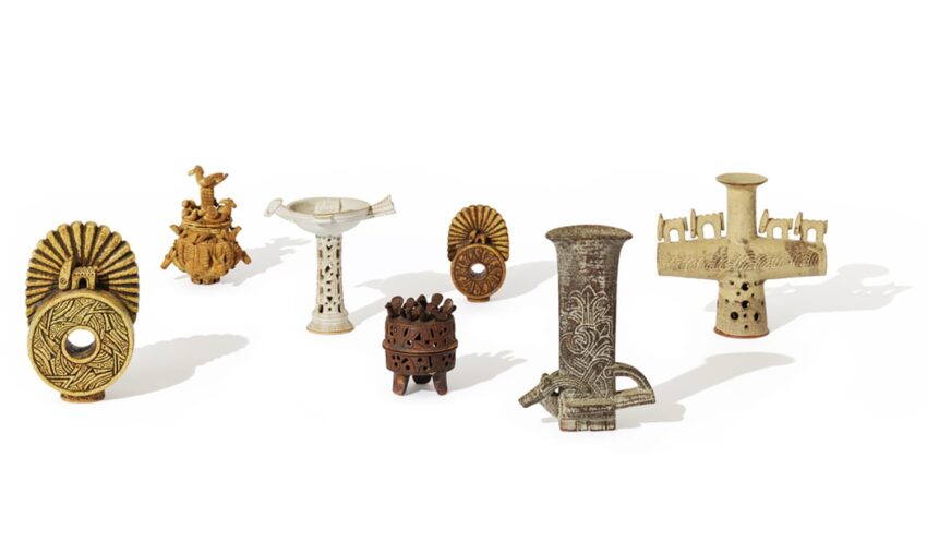 A collection of varied ceramic sculptures with intricate designs displayed against a white background.