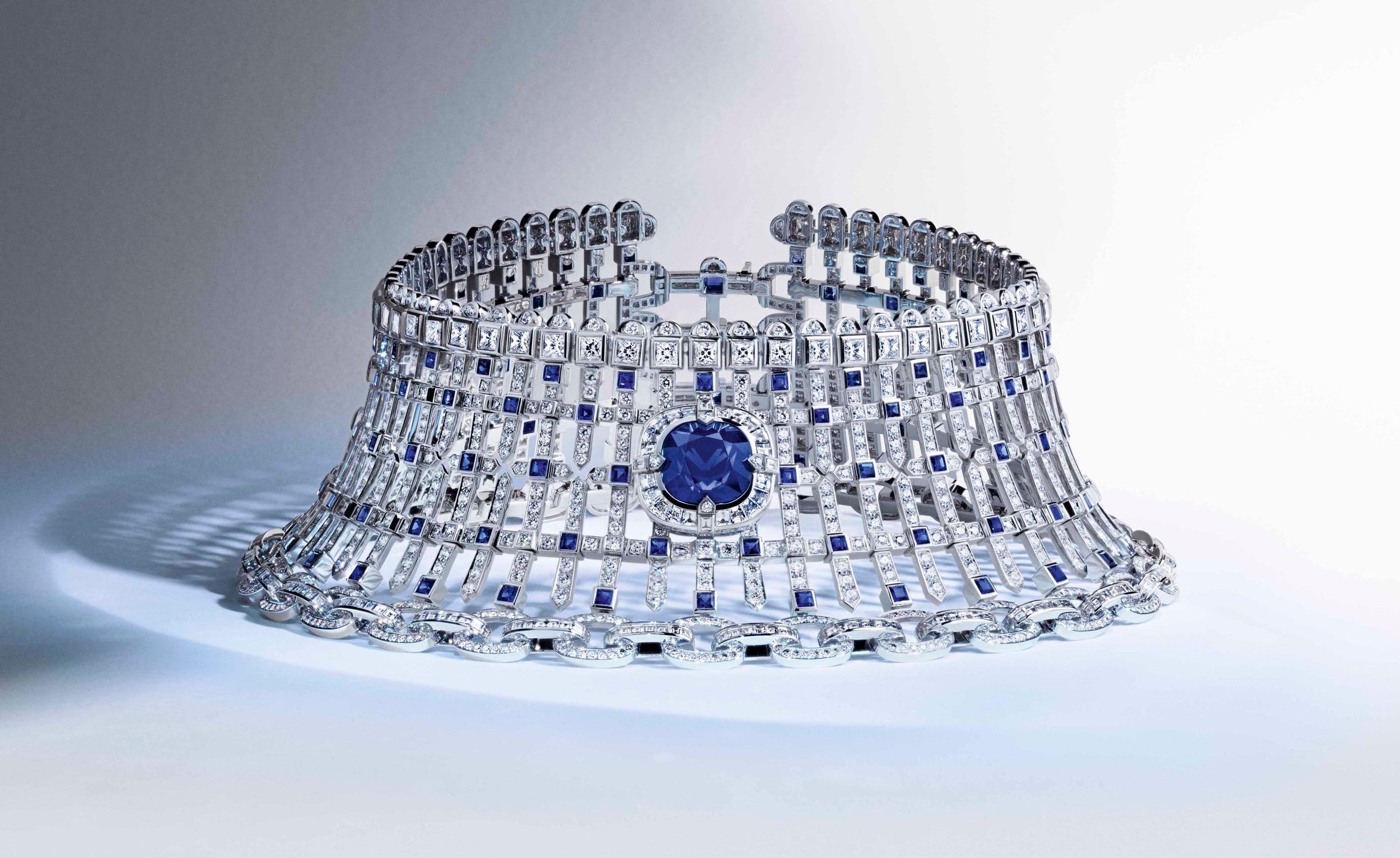 Intricate silver and blue gemstone lattice choker necklace displayed on a light background.