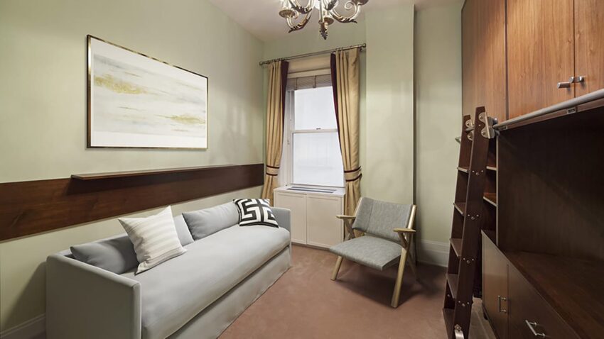 small living room with a gray sofa, modern chair, wall art, and a wooden cabinet near a window with beige curtains