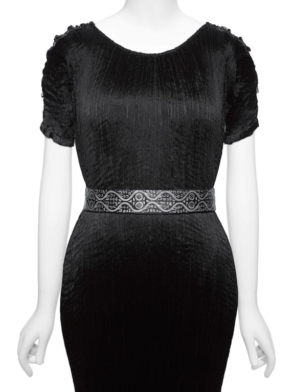 Black textured dress with short sleeves and patterned belt on a mannequin.