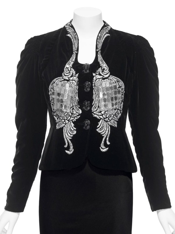 Black velvet jacket with intricate silver embroidery and button details displayed on a mannequin.