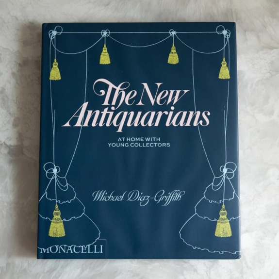 Book cover of "The New Antiquarians" by Michael Diaz-Griffith with decorative tassel illustrations on a blue background.