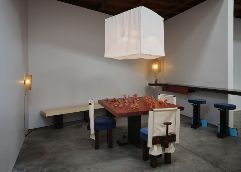 Modern dining area with a wooden table, unique chairs, a bench, and a large white hanging light fixture.