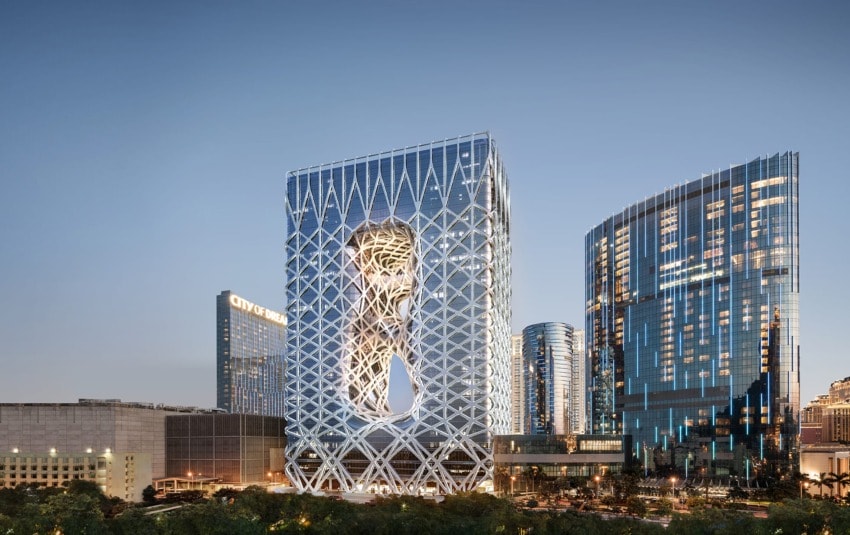 Skyline view of modern city buildings, featuring a uniquely designed tower with a lattice structure and large cutout.