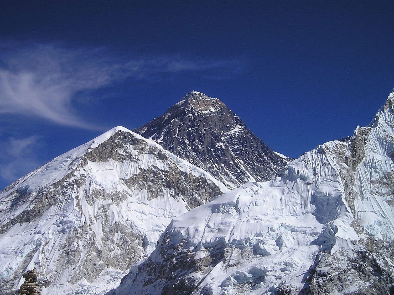 snow-capped Mount Everest under clear blue sky with rocky peaks and glaciers