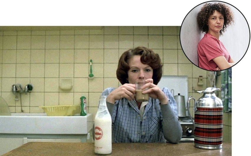 A woman sitting at a kitchen counter with a glass and milk bottle, inset of another woman with curly hair in a pink shirt.