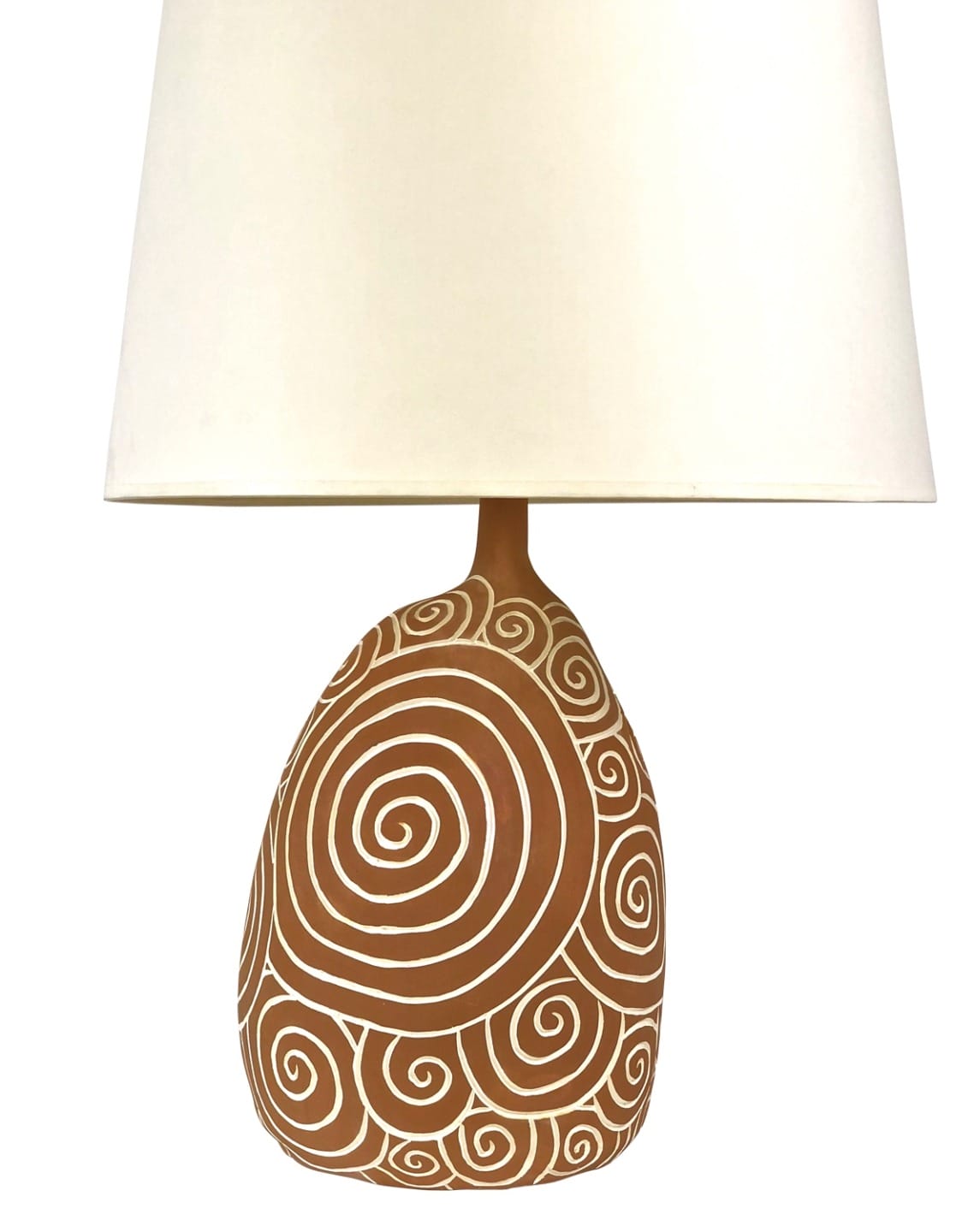 Decorative table lamp with a white shade and a brown base adorned with intricate white spiral patterns.
