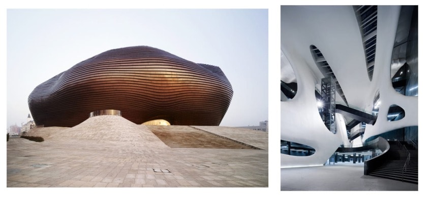 Futuristic building with undulating exterior and modern interior design featuring smooth curves and reflective surfaces.