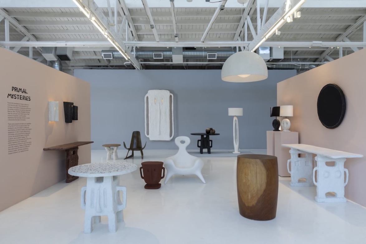 Modern art exhibition with abstract furniture pieces, including tables, chairs, and lamps in a minimalist gallery space.