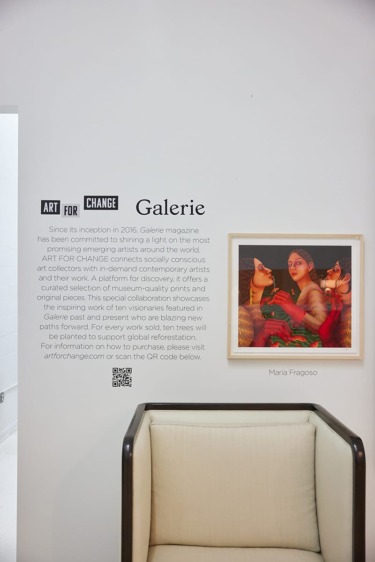 Wall text detailing Galerie's commitment to emerging artists, with a painting by Maria Fragoso next to an armchair.