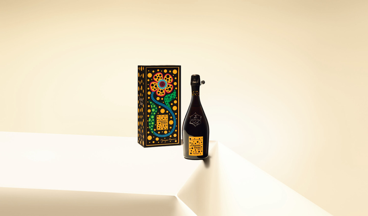 Bottle and box with colorful floral design on a light backdrop, showcasing elegant packaging.