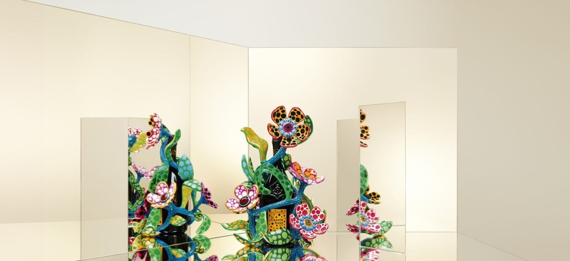 Colorful floral sculpture reflected in mirrors creating an illusion of multiple identical artworks in a gallery setting