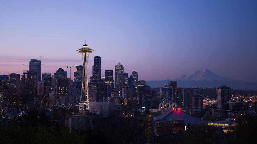 Seattle skyline at dusk with Space Needle and Mount Rainier in the background.