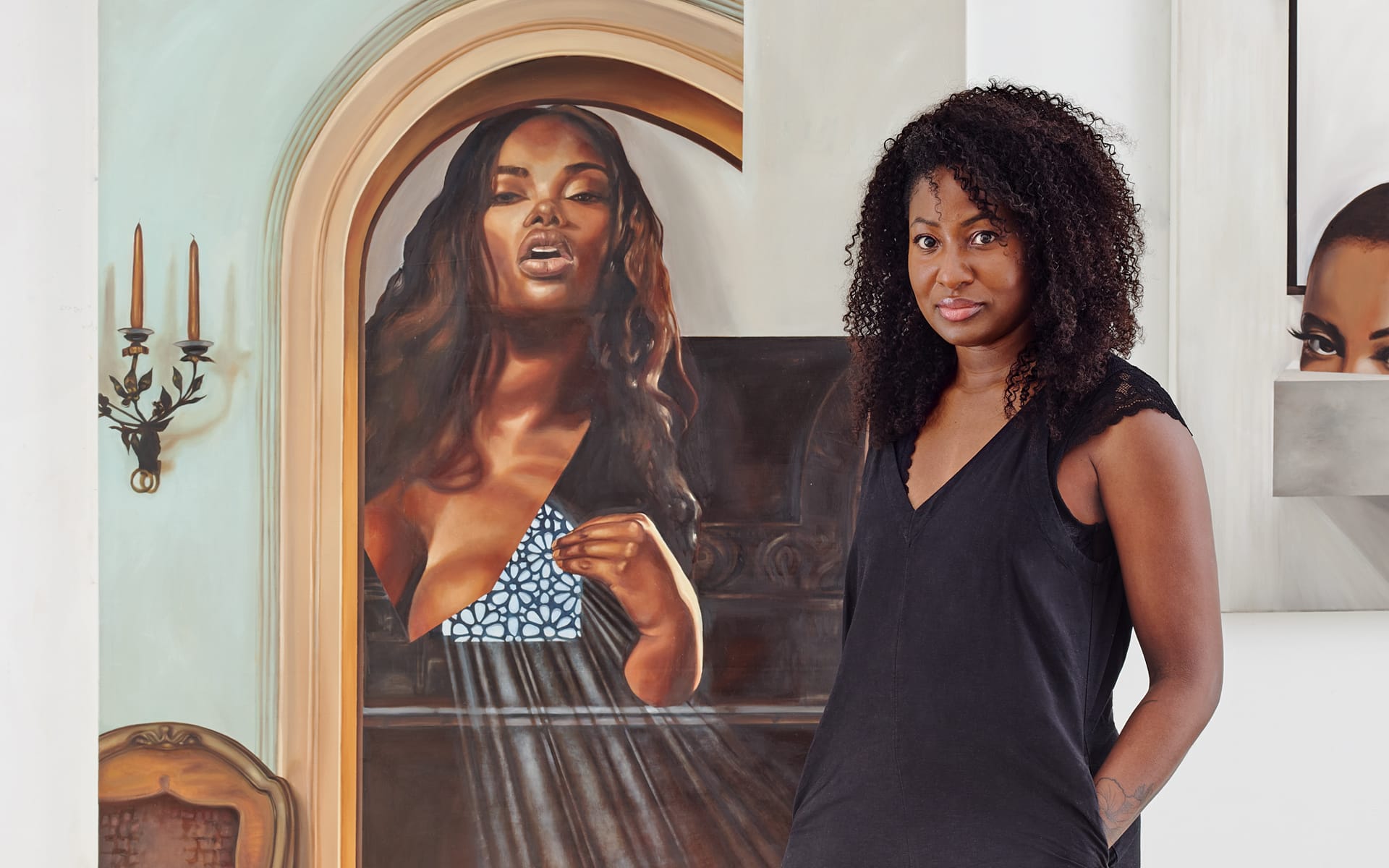 Artist standing next to a painting featuring a woman in an elegant pose, with a background of classical decor.
