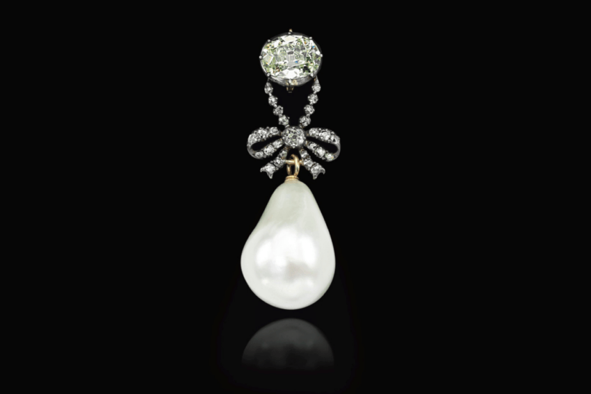 Elegant pearl and diamond pendant with intricate design on a black background