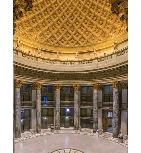 Interior of a grand rotunda with decorative columns, ornate ceiling, and statues, showcasing neoclassical architecture.