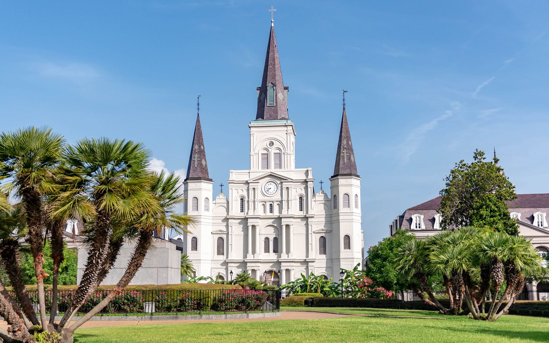 St. Louis Cathedral and gardens in New Orleans under a clear blue sky.