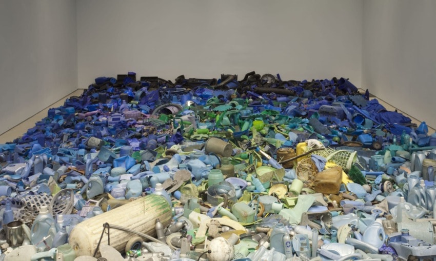 Room filled with various blue and green plastic debris scattered across the floor, creating an ocean-like effect.
