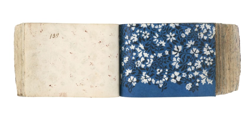 Open book with a floral pattern on the right page and a blank page on the left, numbered 135.