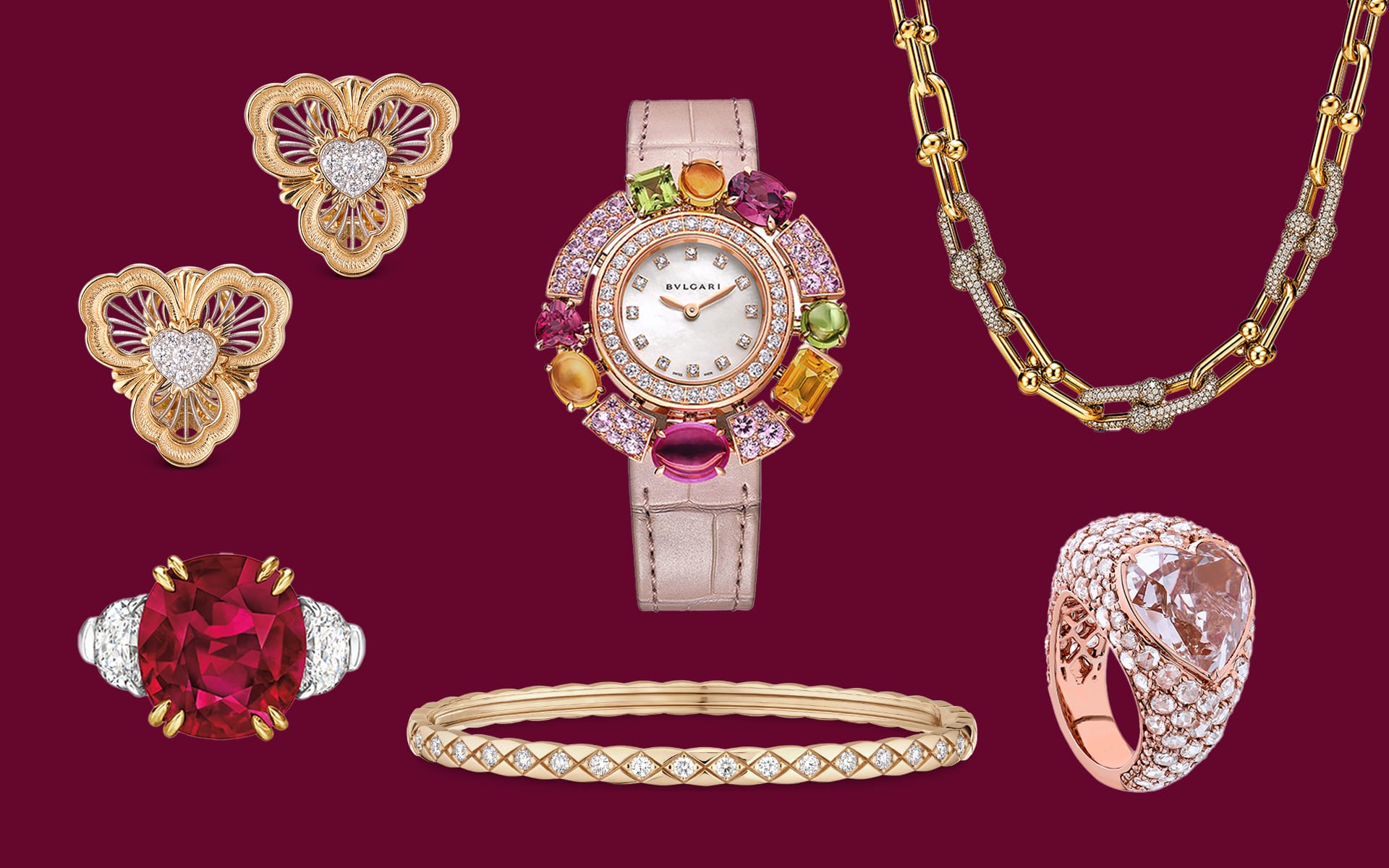 A collection of luxurious jewelry including a watch, gold necklace, earrings, rings, and bracelet with gemstones.