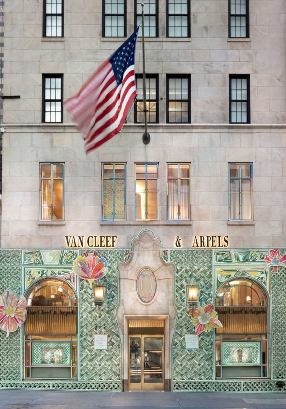 Exterior of Van Cleef & Arpels store with American flag and decorative facade on a city street.