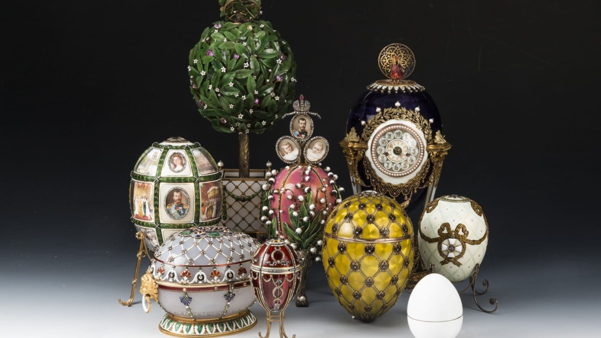 Collection of ornate decorative eggs including Fabergé-style designs with intricate detailing and vibrant colors on display.