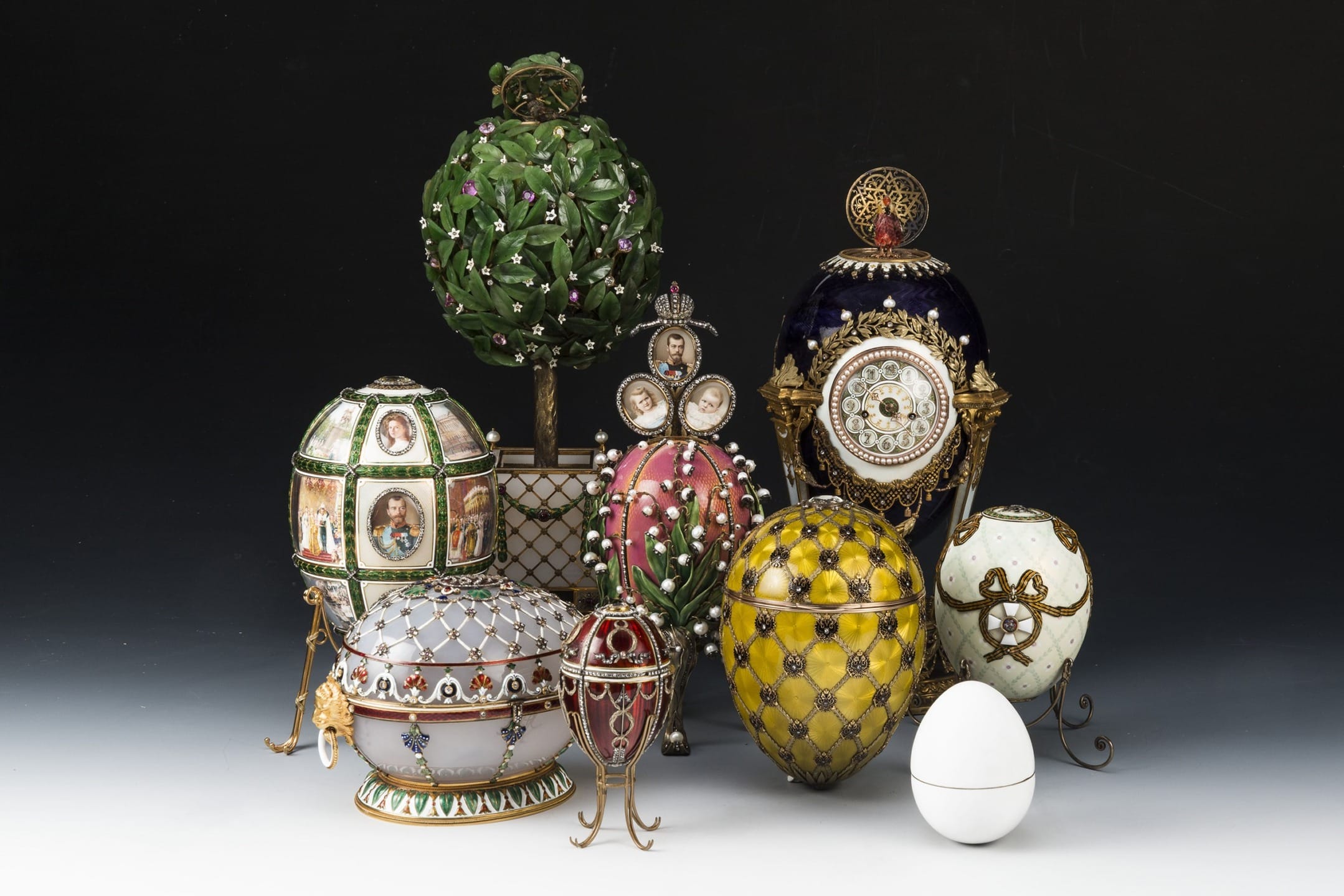 Collection of ornate decorative eggs including Fabergé-style designs with intricate detailing and vibrant colors on display.