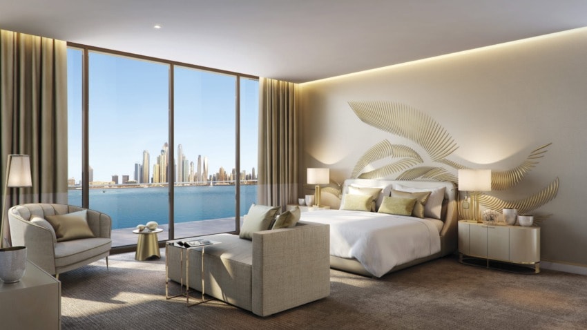 Luxurious bedroom with modern decor, large windows offering a city skyline and waterfront view, elegant furniture arrangement.