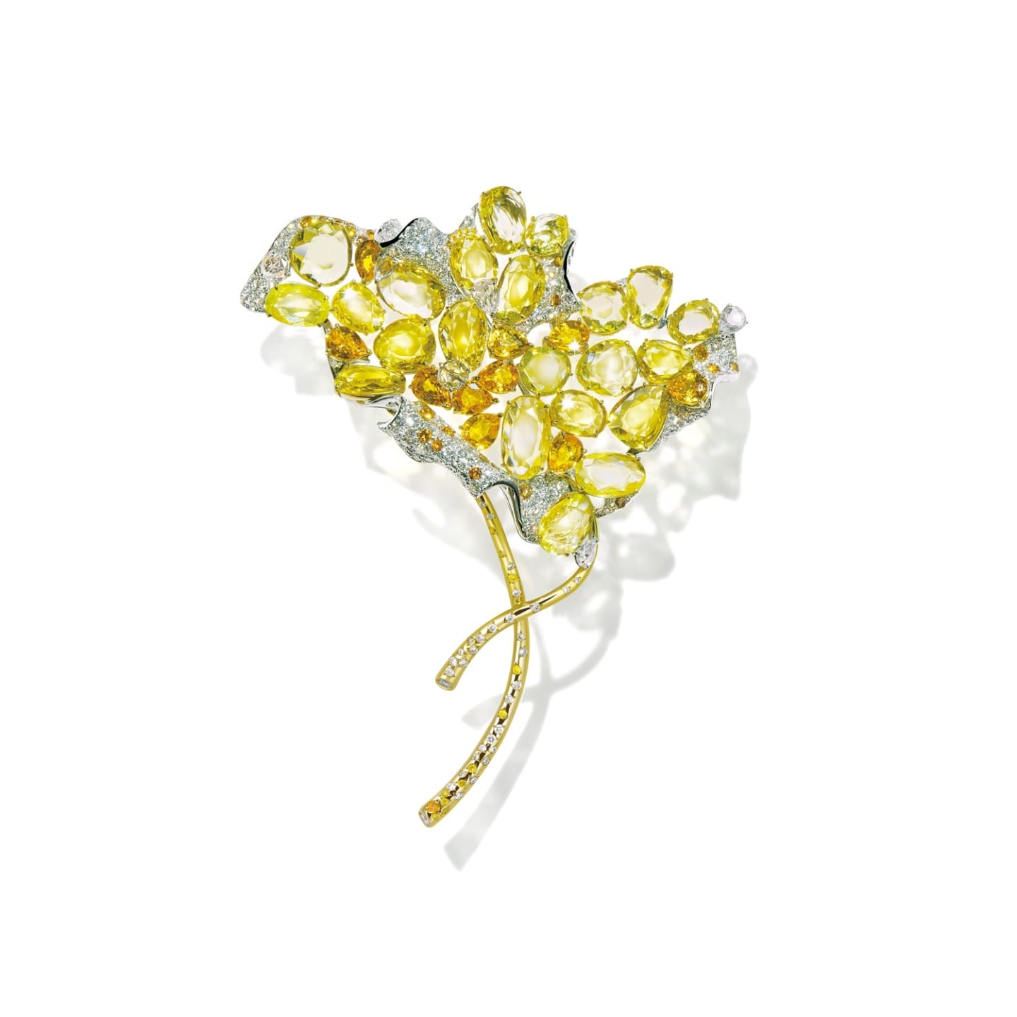 Golden leaf-shaped brooch with sparkling gemstones and intricate design details on a white background.