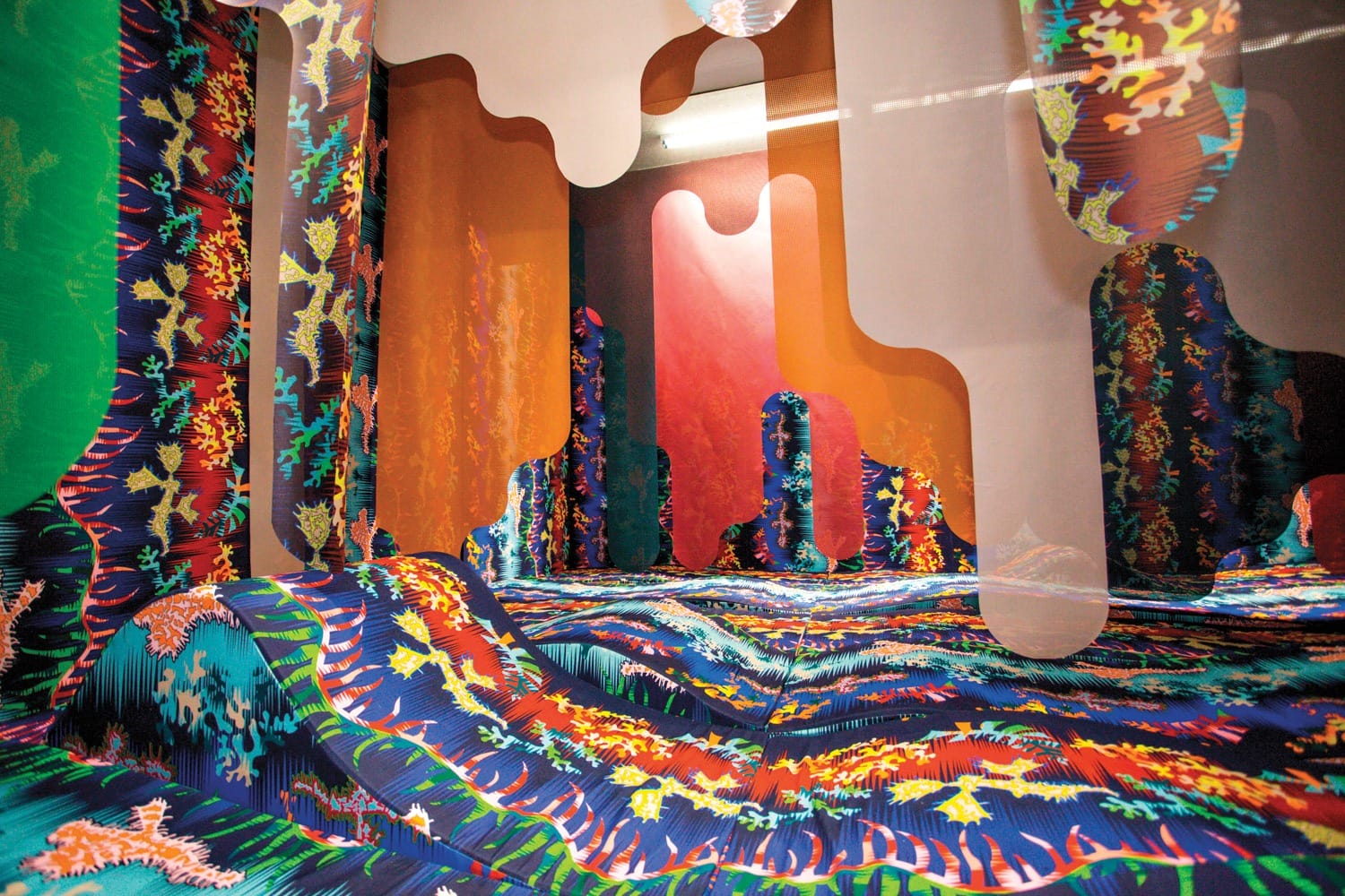 Colorful abstract art installation with vibrant patterns and flowing shapes covering walls and floor in an immersive space
