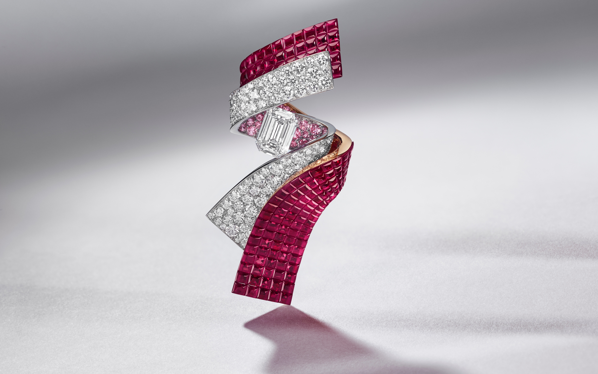 Intricate ruby and diamond jewelry piece on a reflective surface, showcasing elegance and craftsmanship.
